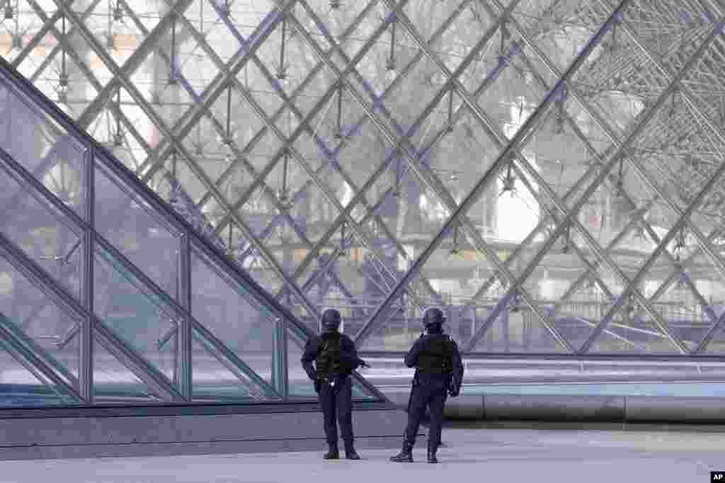 Police officers patrol at the pyramid outside the Louvre museum in Paris, after a knife-wielding man shouting "Allahu akbar'' attacked French soldiers in the area.