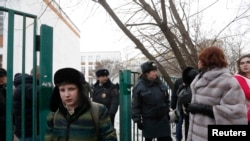 Interior Ministry members evacuate people after an armed student took hostages at a high school on the outskirts of Moscow, Feb. 3, 2014.