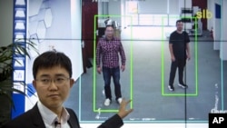 In this Oct. 31, 2018, photo, Huang Yongzhen, CEO of Watrix, demonstrates the use of his firm's gait recognition software at his company's offices in Beijing. 