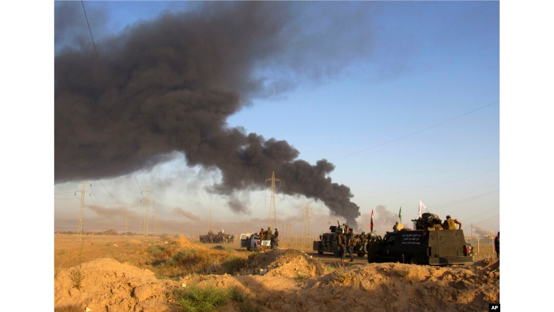 FILE - Smoke rises from Islamic State group positions after an airstrike by U.S.-led coalition warplanes in Fallujah, as Iraqi security forces and allied Shiite Popular Mobilization Forces and Sunni tribal fighters, take combat positions outside Fallujah, May 23, 2016.