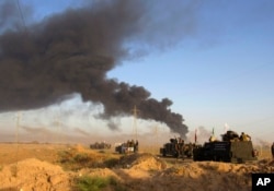 Smoke rises from Islamic State group positions after an airstrike by U.S.-led coalition warplanes in Fallujah, as Iraqi security forces and allied Shiite Popular Mobilization Forces and Sunni tribal fighters, take combat positions outside Fallujah, May 23