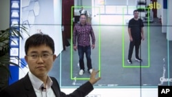 In this Oct. 31, 2018, photo, Huang Yongzhen, CEO of Watrix, demonstrates the use of his firm's gait recognition software at his company's offices in Beijing. 