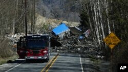 23일 미국 워싱턴주 오소시 인근에서 산사태로 무너져 내린 흙더미가 도로를 덮쳤다. 흙더미에 휩쓸려온 가옥도 보인다.