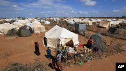 Refugees stand outside their tent at the Ifo Extension refugee camp in Dadaab, near the Kenya-Somalia border (File)