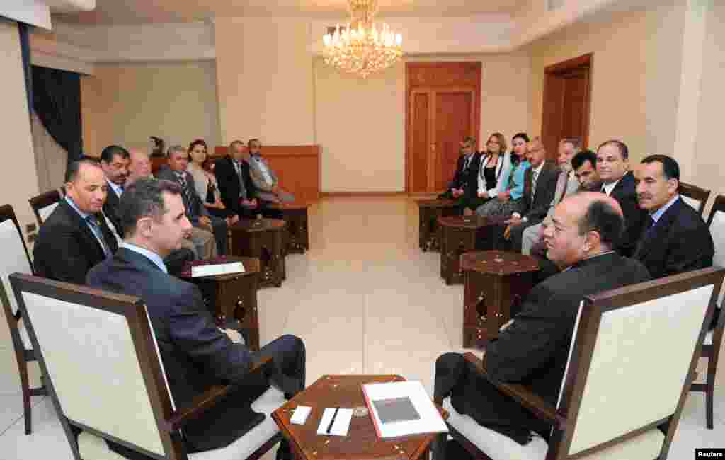Syria's President Bashar al-Assad (L) speaks with Shukri Bin Suleiman Harmasi (R), secretary general of the Tunisian Immutable Principles Party, during a meeting in Damascus, May 23, 2013. 