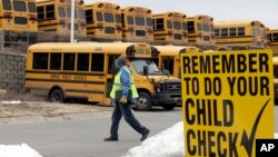 FILE - A driver walks away from the school bus parking lot after his morning shift, in Omaha, Nebraska. 