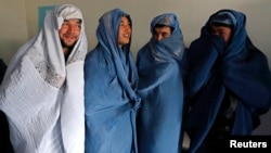 Male Afghan women's rights activists pose for media as they wear burqas to show their solidarity to Afghan women ahead of International Women's Day in Kabul, March 5, 2015. 