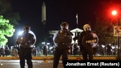 Polisi wakiwafukuza Waandamanaji katikati ya tukio hilo ambapo wanaandamana kupinga mauaji ya George Floyd akiwa chini ya ulinzi wa polisi huko Minneapolis. Maandamano hayo yalifanyika karibu na White House, Washington, DC. Picture taken May 31, 2020. REUTERS/Jonathan Ernst