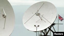 FILE - Satellite dishes are seen at GCHQ's outpost at Bude, close to where trans-Atlantic fiber-optic cables come ashore in Cornwall, southwest England June 23, 2013. On Monday, with a simple "Hello, world," the secretive agency joined the Twittersphere.