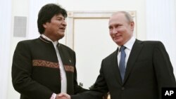 FILE - Russian President Vladimir Putin, right, shakes hands with Bolivia's President Evo Morales before their talks in the Kremlin, in Moscow, July 11, 2019. 