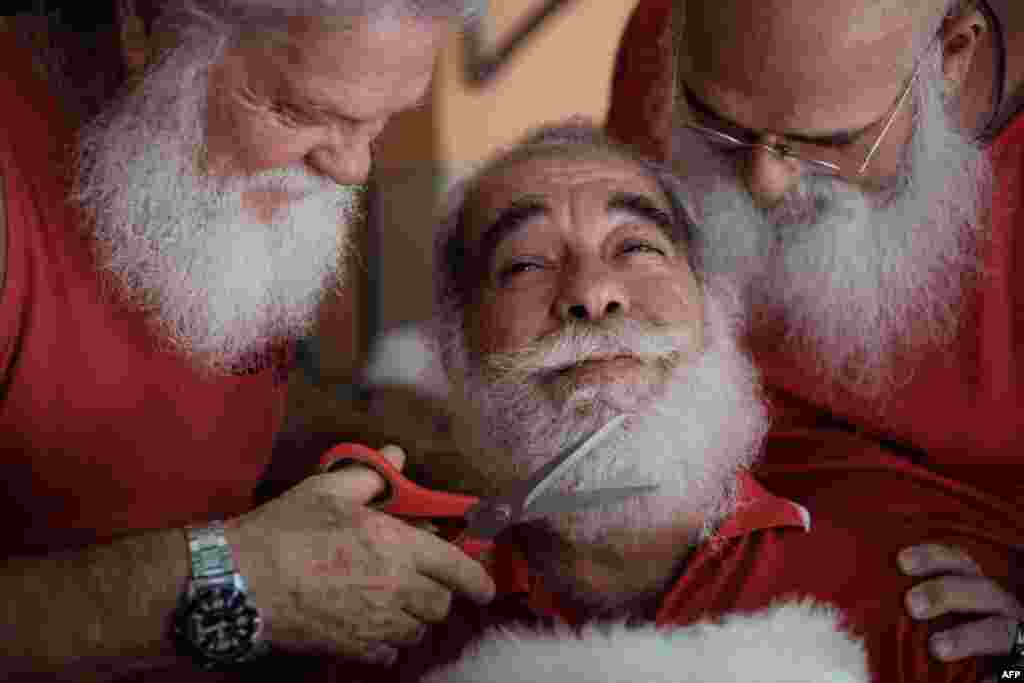 A graduate of the Brazil&#39;s School of Santa Claus gets his beard trimmed by students in Rio de Janeiro.