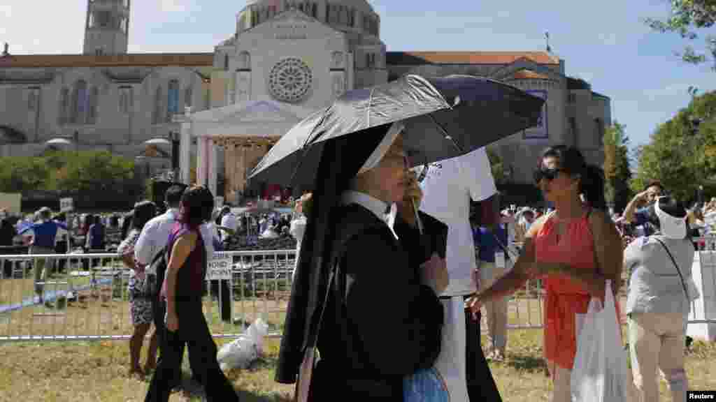 Une religieuse se couvre parmi d&#39;autres personnes venues assister à la canonisation du moine Friar Junipero Serra par le pape François à la Basilique de l&#39;Immaculée Conception à Washington, 23 septembre 2015.