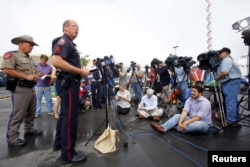 Sgt. Patrick Swanton Waco Police Department spokesman, speaks to the media near the Twin Peaks restaurant where members of a motorcycle gang were shot and killed in Waco, Texas, May 19, 2015.