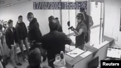 This video grab from a security camera shows the moment where armed police break in to Voluntad Popular (Popular Will) headquarters in Caracas, Feb. 17, 2014. Videos sent to media by Popular Will, which could not be independently identified, showed men entering the premises waving guns and trying to kick down a door. 