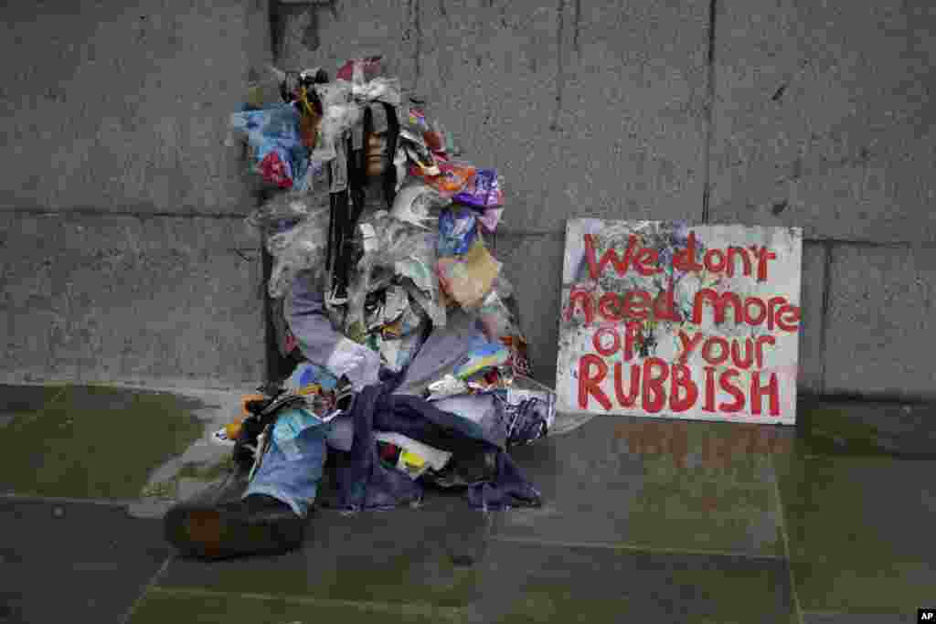 Mwanaharakati wa kundi la Extinction Rebellion akikaa nje ya jengo la bunge la Uingereza mjini London, siku ya jumatatu wakati kundi lake likifunga njia muhimu mjini London, Berlin na Amsterdam Oct 7 2019 wakianza malalamiko ya wiki nzima kutaka hatua kuchukuliwa kukabiliana na mabadiliko ya hali ya hewa duniani. (AP)