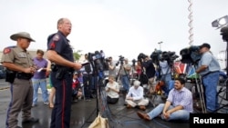 Sgt. Patrick Swanton, second from left, Waco Police Department spokesman, speaks to the media near the Twin Peaks restaurant where nine members of a motorcycle gang were shot and killed Sunday in Waco, Texas, May 19, 2015. 