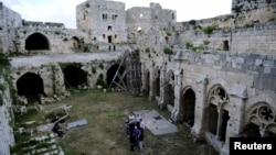 FILE - Experts gather as they discuss the restoration process of the Crusader castle of Crac des Chevaliers, in Homs province, Syria, May 24, 2016.