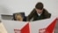 The candidate for Warsaw mayor for the pro-European Union Civic Platform party, Rafal Trzaskowski, with his son Stasio, check voting lists in local elections that were the test of support for the ruling right-wing Law and Justice party, whose policies have produced street protests and repeated clashes with European Union leaders, in Warsaw, Poland, Sunday, Oct. 21, 2018.
