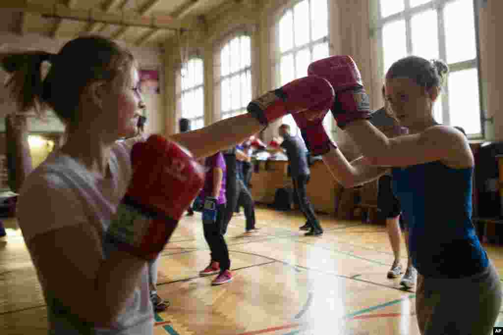 Dua perempuan dalam pelatihan tinju Boxgirls Berlin untuk memperingati Hari Perempuan Internasional di Berlin, Jerman. Pelatihan ini mendorong perempuan dan gadis remaja menggunakan tinju sebagai katalis untuk perubahan sosial di kota-kota mereka dengan slogan "Perempuan Kuat, Selamatkan Komunitas". (AP/Markus Schreiber)