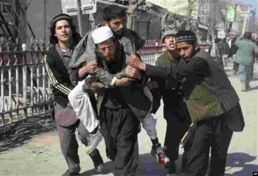 Afghans carry a wounded man during an anti-U.S. demonstration in Kunduz, north of Kabul, Afghanistan, Saturday, Feb. 25, 2012.