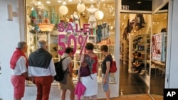 Window shoppers look into a store in Miami Beach, Florida, April 26, 2017.