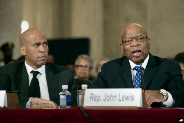 Sen. Cory Booker, D-N.J., listens at left as Rep. John Lewis, D-Ga. testifies on Capitol Hill in Washington, Jan. 11, 2017, at the second day of a confirmation hearing for Attorney General-designate, Sen. Jeff Sessions, R-Ala., before the Senate Judiciary Committee.