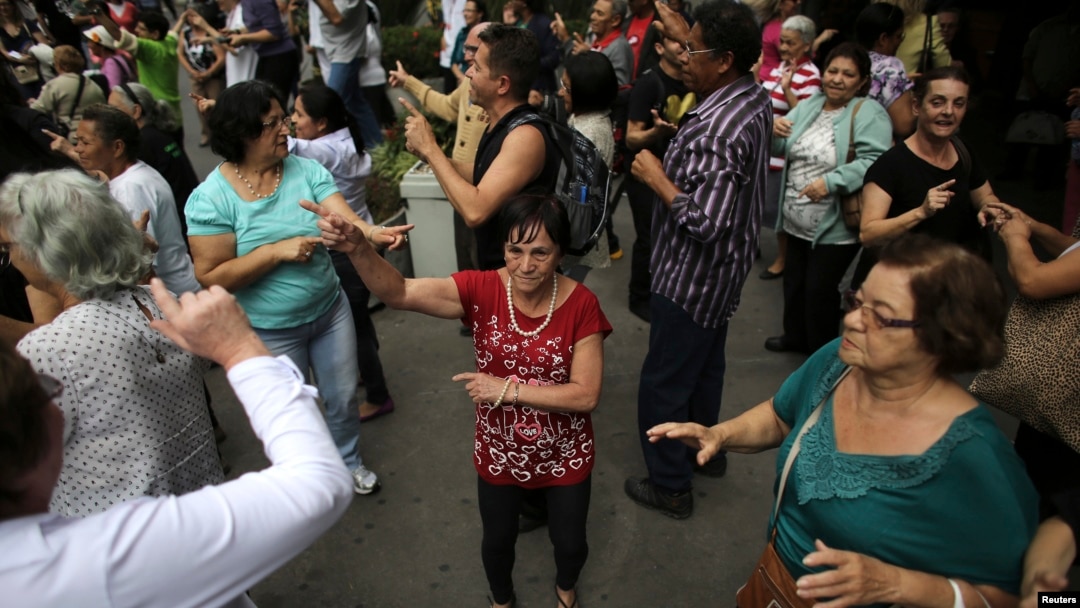 FILE - Elderly people dance on a street during the International Day of Older Persons in Sao Paulo's Avenida Paulista, Brazil, October 2013.