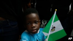 FILE— A child holds a Nigeria flag in Lagos, Nigeria, October 19, 2020. 