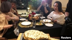 A customer takes pictures of a gold leaf-coated steak, tapping in on a wave of publicity after a government minister was caught on camera being fed the dish at a London restaurant, at a Dolce By Wyndham Hanoi Golden Lake hotel, in Hanoi, Vietnam December 7, 2021. (REUTERS)