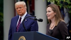 President Donald Trump walks with Judge Amy Coney Barrett to a news conference to announce Barrett as his nominee to the Supreme Court, in the Rose Garden at the White House, Sept. 26, 2020, in Washington. 