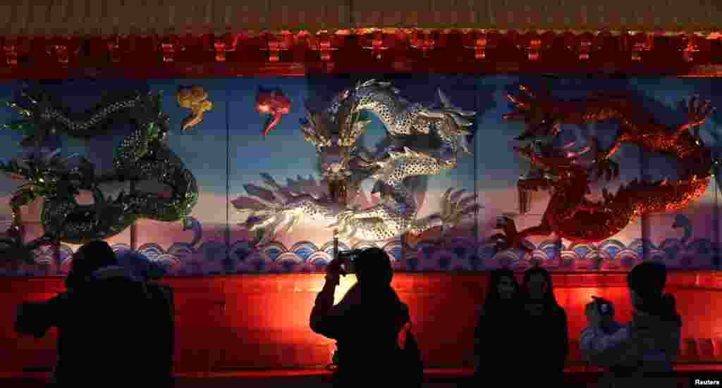 People take pictures of an installation during Chinese Lunar New Year celebrations at the Old Town Square in Prague, Czech Republic, Feb. 19, 2015.