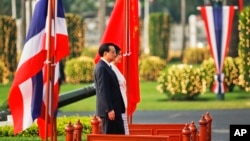 Thailand's Prime Minister Yingluck Shinawatra and China's Premier Li Keqiang listen to national anthems during welcoming ceremony, government house, Bangkok, Oct. 11, 2013.