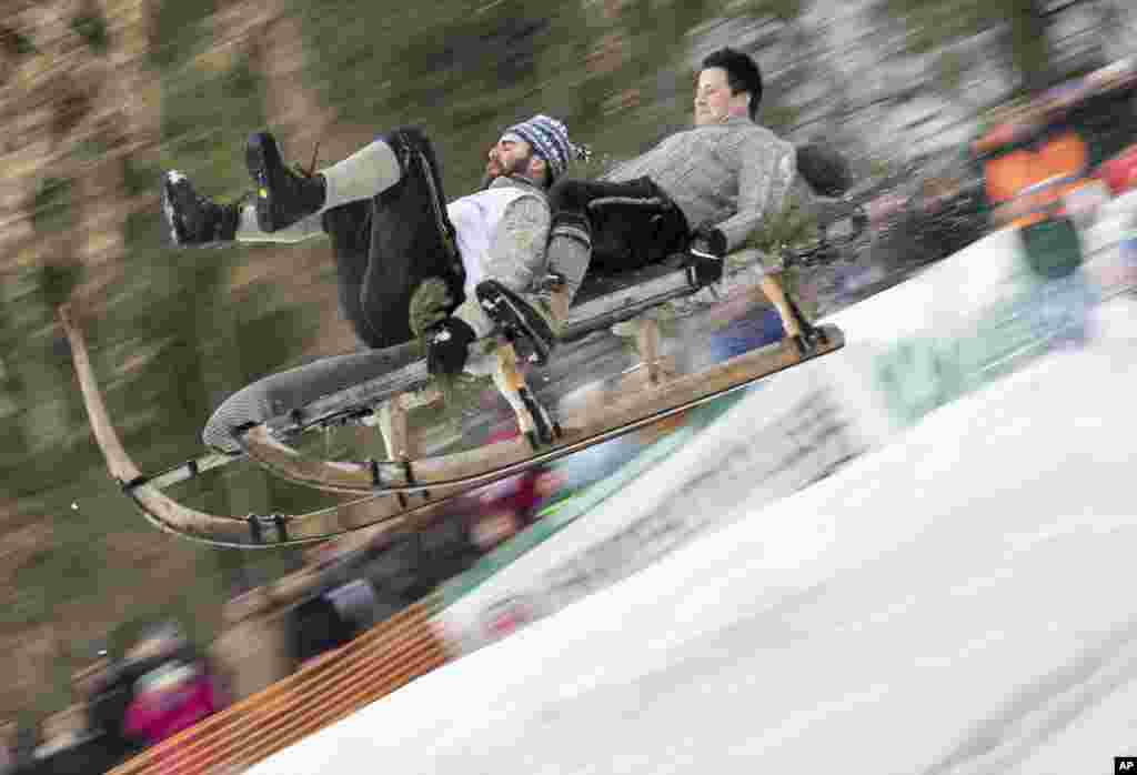 Two men ride down in a traditional sled called a Schnabler during a race in Gaissach, southern Germany.