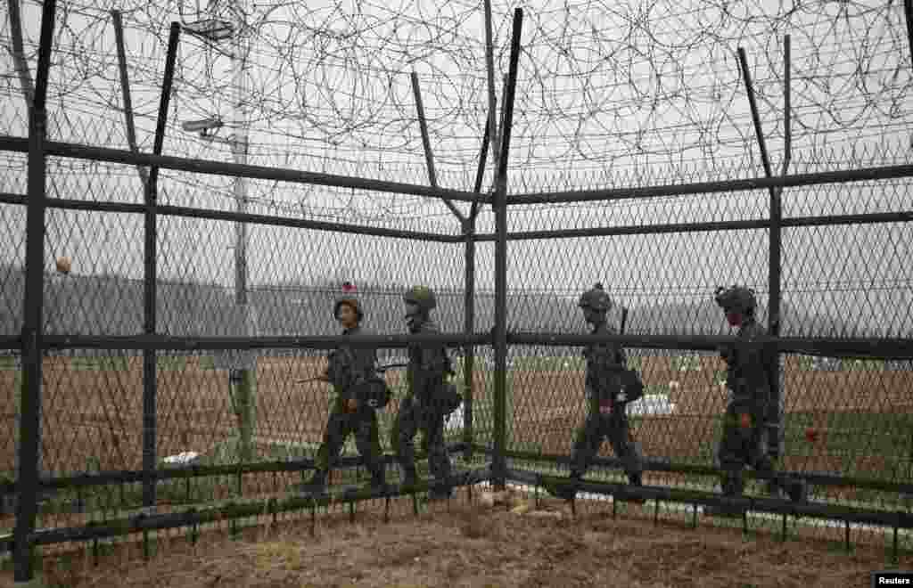 South Korean soldiers patrol along a barbed-wire fence, near the demilitarized zone that separates the two Koreas in Paju, north of Seoul, April 5, 2013. 
