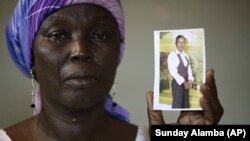 Martha Mark, ibu dari Monica Mark yang diculik Boko Haram, memperlihatkan foto putrinya di rumahnya di Chibok, Nigeria. (AP/Sunday Alamba)