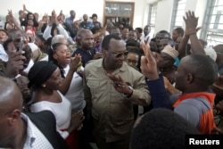 FILE - Freeman Mbowe, center, chairman of Chadema, Tanzania's main opposition party, arrives at Kisutu Magistrate Court in Dar es Salaam, Tanzania, March 10, 2020.