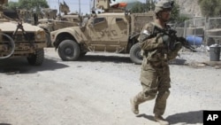 A US soldier, part of the NATO forces, patrols a police station after it was attacked by militants, Kandahar, Afghanistan, June 19, 2012.