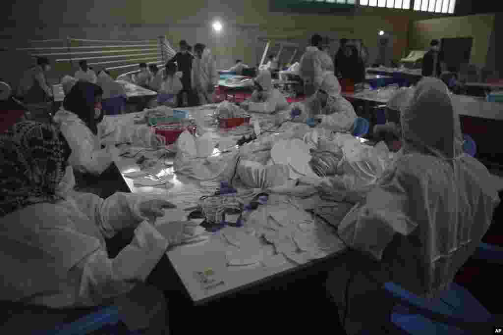 کارگران یک کارگاه مشغول تهیه ماسک&zwnj;های محافظتی برای پیشگیری از شیوع کرونا در کابل، افغانستان