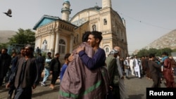 Afghans greet each other outside the Shah-e Doh Shamshira Mosque, on the first day of Eid al-Fitr, which marks the end of the holy month of Ramadan, in Kabul, Afghanistan, June 15, 2018.