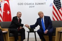 FILE - President Donald Trump shakes hands with Turkish President Recep Tayyip Erdogan during a meeting on the sidelines of the G-20 summit in Osaka, Japan, June 29, 2019.