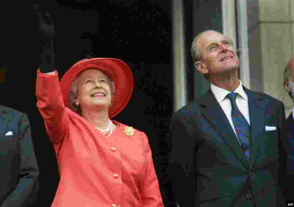 Queen Elizabeth and Prince Philip look up from the balcony of Buckingham Palace in London as a Concorde flies past during the Golden Jubilee celebrations in London, June 4, 2002. (AP)