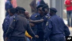 An unidentified journalist from an opposition television station is detained and roughed up by police while covering an opposition protest in Kinshasa, Congo on Thursday, Sept. 1, 2011.