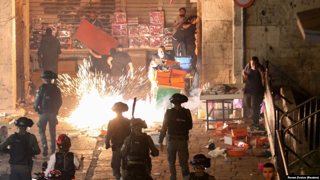 Sejumlah orang Palestina bereaksi saat polisi Israel menembakkan granat kejut dalam bentrokan di Gerbang Damaskus pada malam Laylatulqadar di bulan Ramadan, di Kota Tua Yerusalem, Sabtu, 9 Mei 2021. (Foto: Ronen Zvulun/Reuters)
