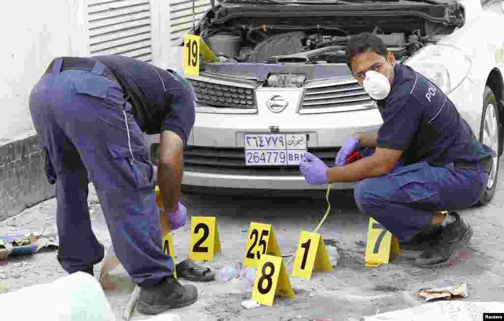 Police officials work at a bomb site in Manama, Bahrain, November 5. Five bombs exploded, killing two people