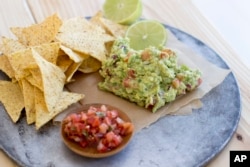 FILE - Basic guacamole and tortilla chips are seen in Concord, New Hampshire, Dec. 14, 2015. There are multiple ways to serve up guacamole for the Super Bowl.