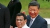 FILE - Chinese President Xi Jinping and Philippine President Rodrigo Duterte wave to the media following a welcome ceremony at Malacanang Palace in Manila, Philippines, Nov. 20, 2018. 