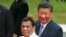 FILE - Chinese President Xi Jinping and Philippine President Rodrigo Duterte wave to the media following a welcome ceremony at Malacanang Palace in Manila, Philippines, Nov. 20, 2018. 