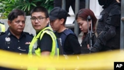 Terdakwa Siti Aisyah (dua dari kanan) dikawal ketat polisi saat keluar dari gedung pengadilan di Sepang, Malaysia, 1 Maret 2017. (AP Photo/Daniel Chan) 