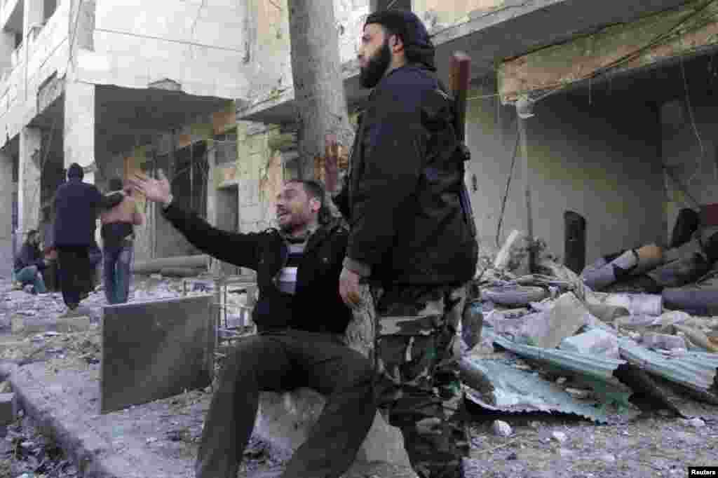 مرد به خرابه های ناشی از حمله هوایی منسوب به نیروهای بشار اسد در حلب اشاره می کند.&nbsp; 