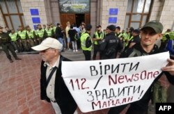 FILE - Activists protest against TV channels they see as agents of Russian disinformation, in Kyiv, Sept. 5, 2019. Their sign reads "To believe TV channels '112' and 'NewsOne' is to betray the 'Maidan' (Ukraine's revolution of dignity)."